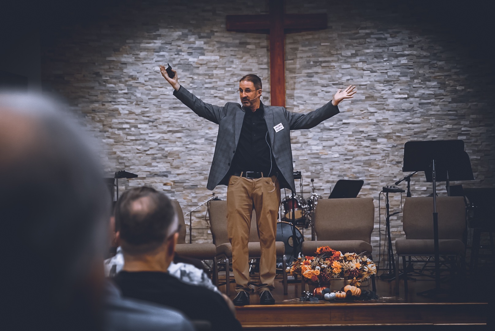 A speaker addresses the men of The Micah Mandate beneath the cross